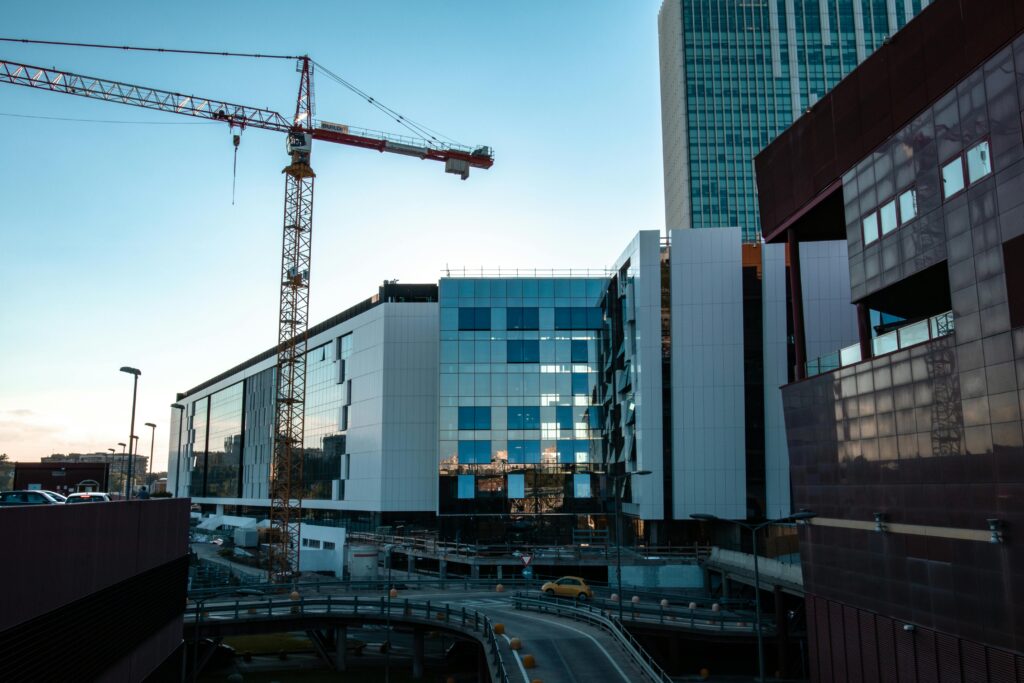 Contemporary building under construction with cranes, showcasing urban architecture and development.